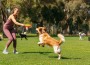 Woman,Playing,Fetch,With,Dog,In,Dog,Park